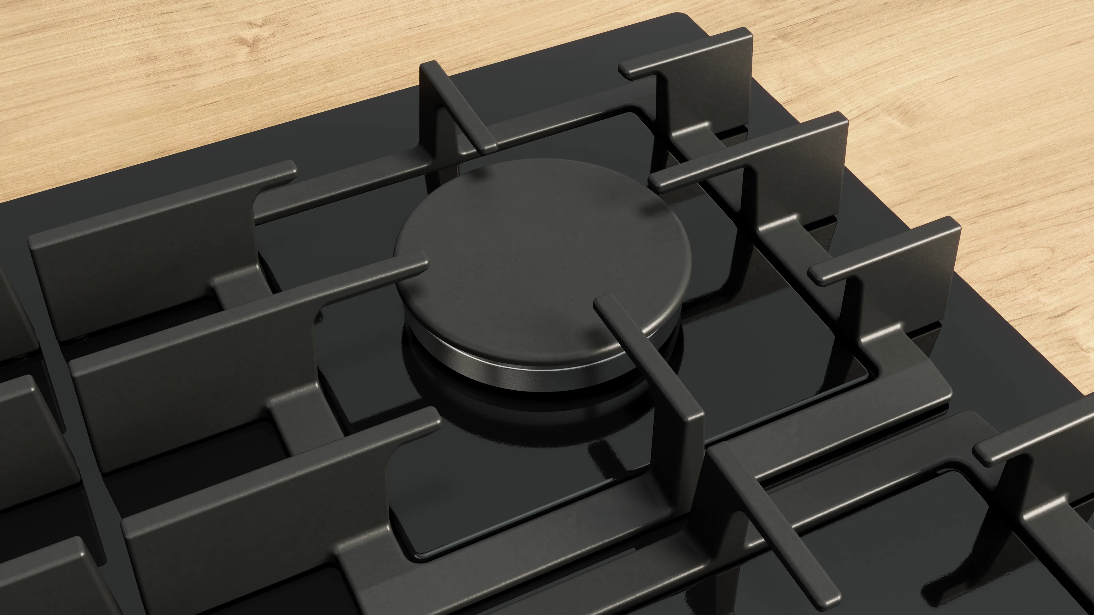 Närbild av en modern svart gashäll med ett runt brännarlock, mot en träbänkskiva.