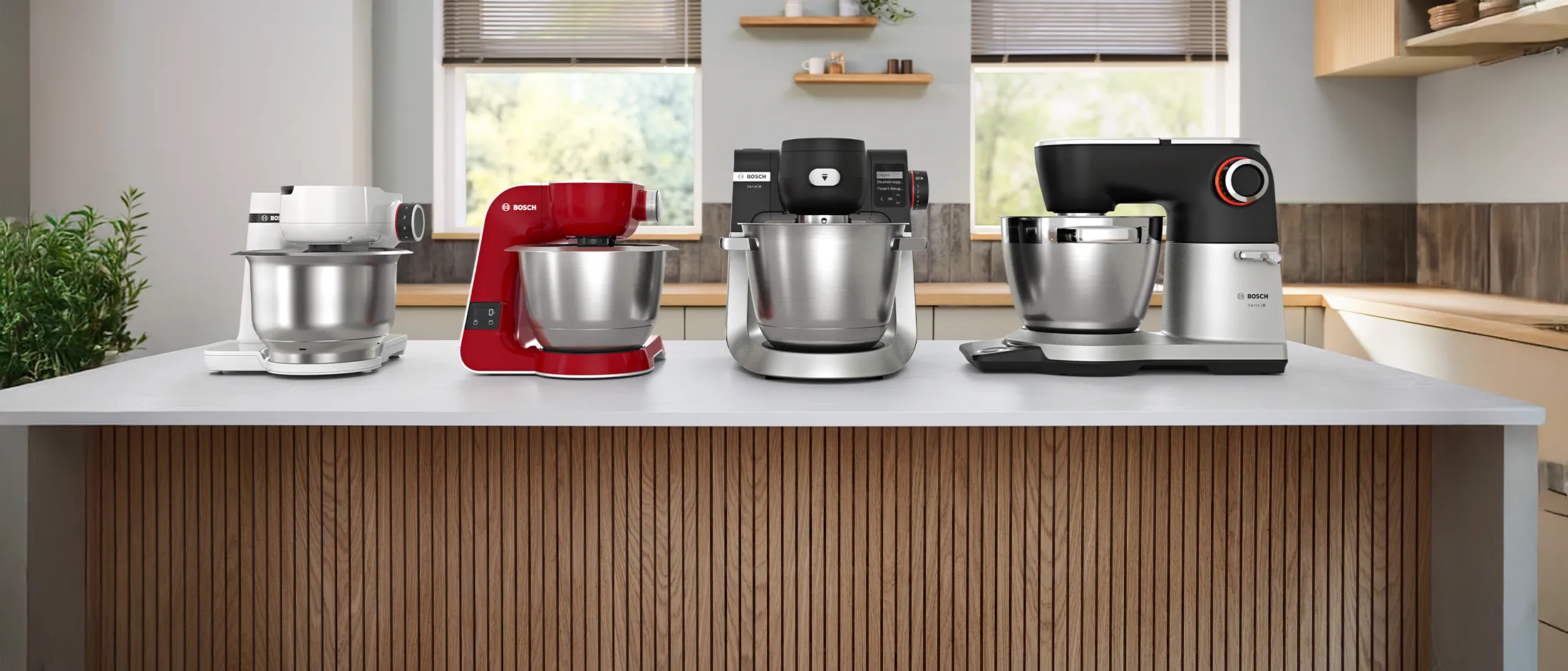 Line up of the four stand mixers on a kitchen worktop.