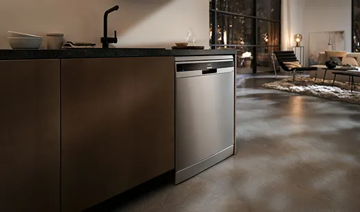 A modern kitchen featuring a freestanding stainless steel dishwasher beside sleek cabinetry and countertops.  