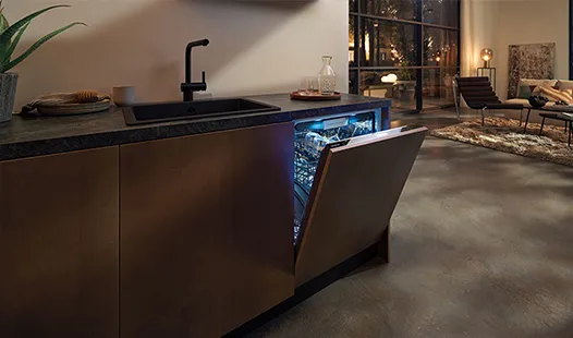 A kitchen featuring a sink, refrigerator, and built-in dishwasher, showcasing a modern and functional design.