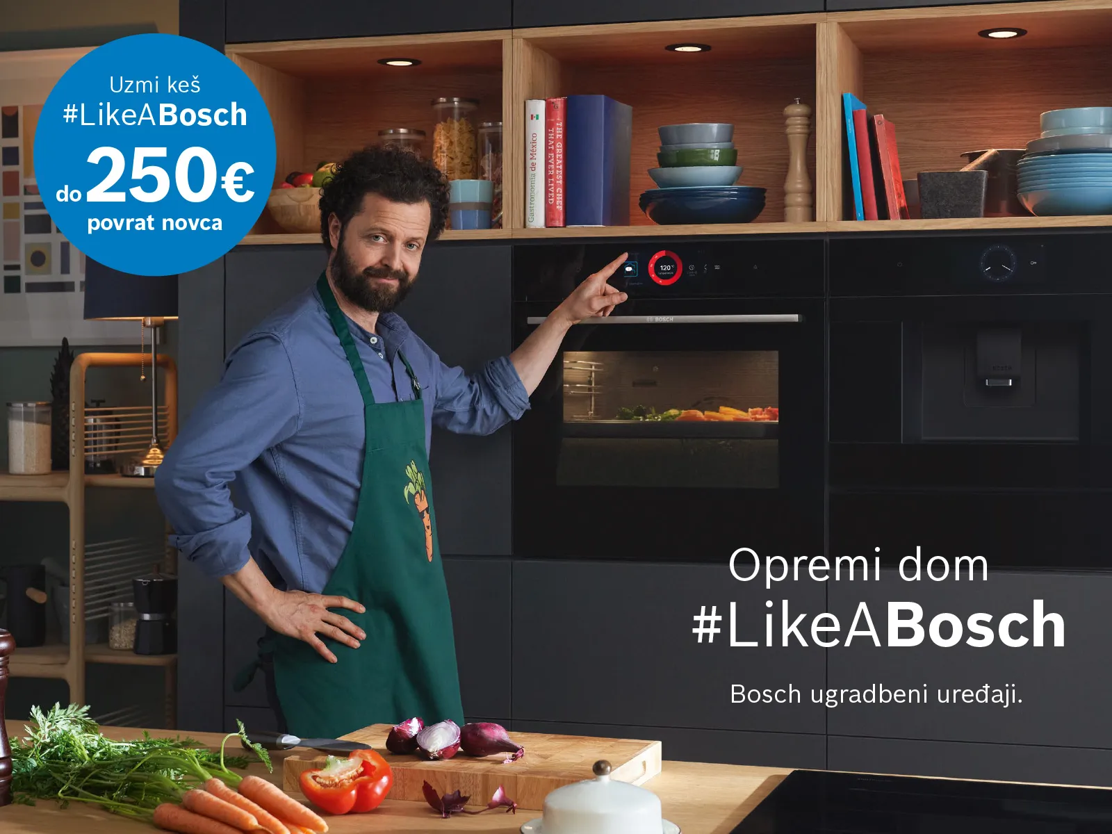 Osoba u pregači pokazuje na Bosch pećnicu u modernoj kuhinji, okružena svježim povrćem i posuđem. Priložen je promotivni tekst.