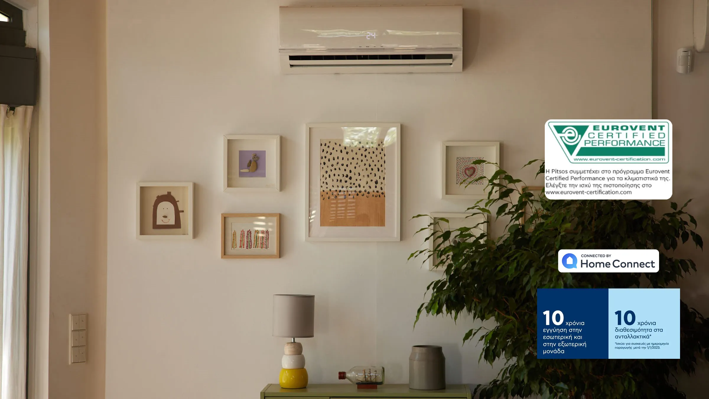 Μια ζεστή σκηνή σαλονιού με μπεζ τοίχο, πολλά καδράκια κρεμασμένα, ένα air condition pitsos και δεξιά badges.