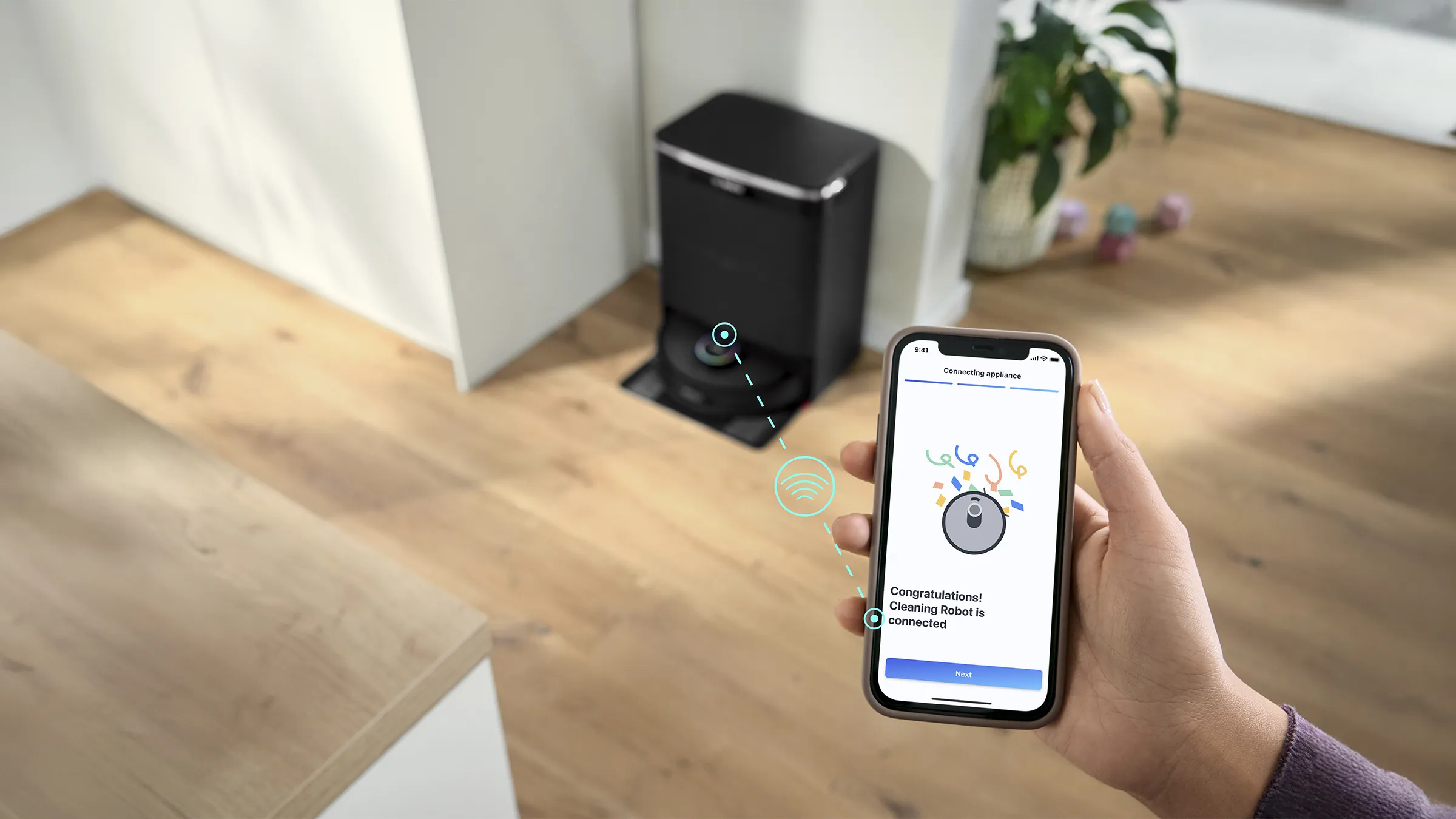 Mano che completa la configurazione di un robot aspirapolvere Bosch tramite l'app Home Connect su uno smartphone.