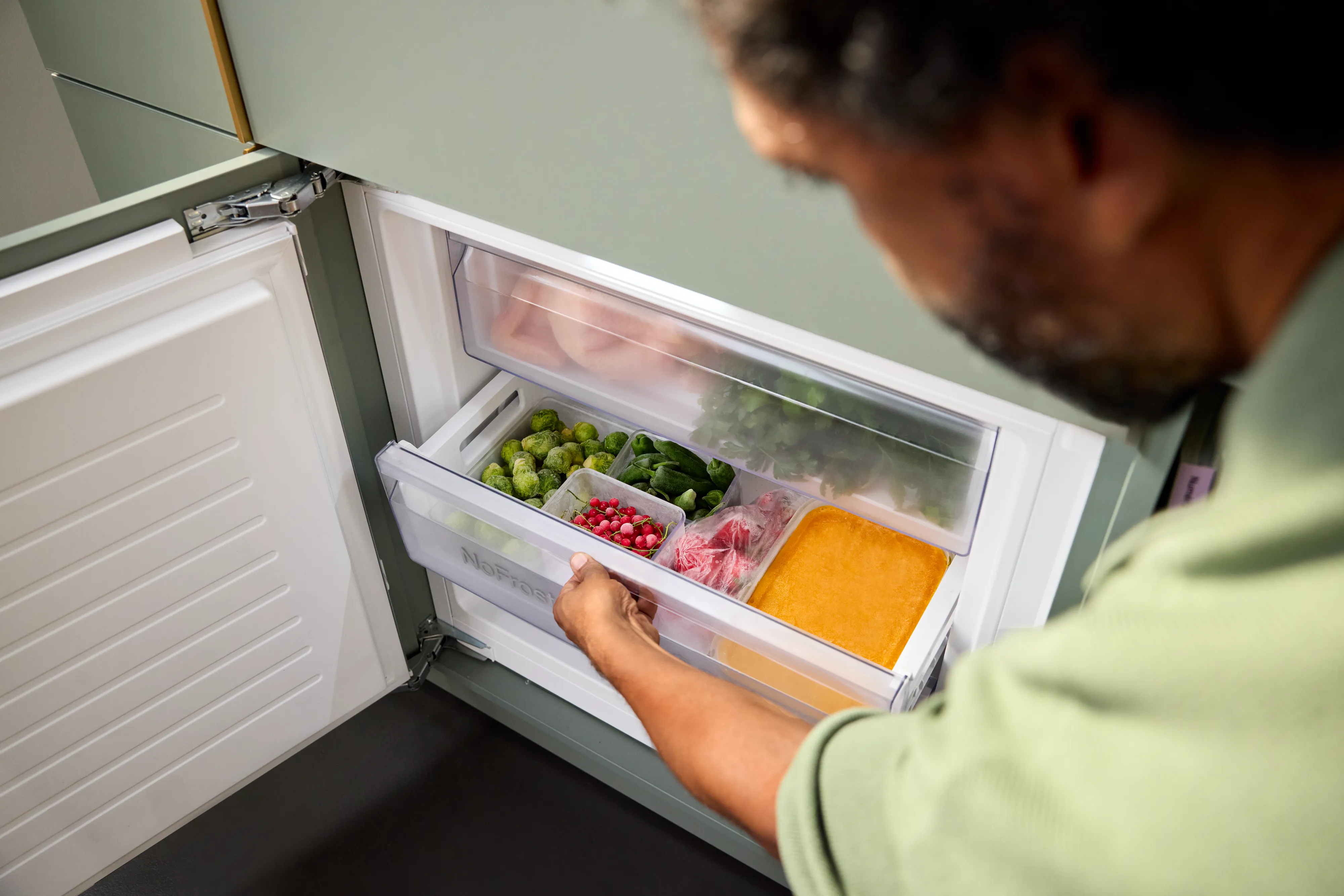 Person öffnet die BigBox-Gefrierschublade einer NEFF Einbau-Kühl-Gefrierkombination mit No Frost.