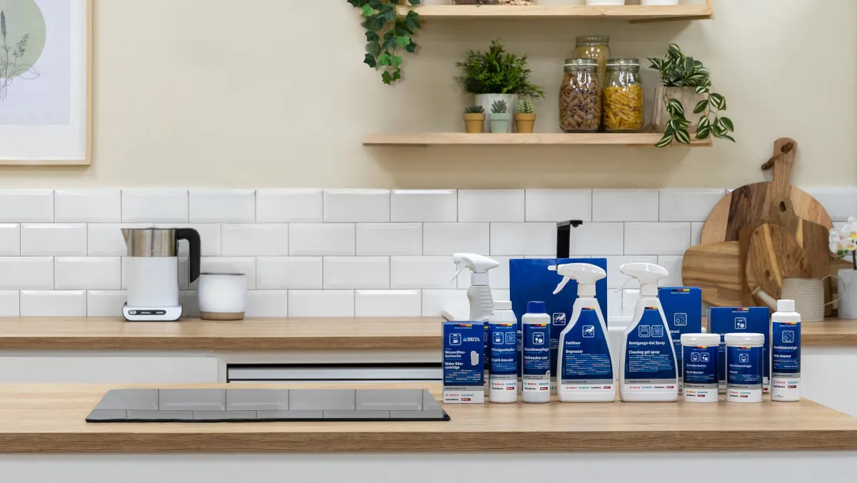 Produits de nettoyage Bosch alignés sur un plan de travail de cuisine moderne avec carrelage blanc en arrière-plan