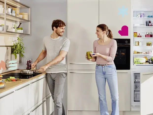 Paar Kochen zusammen in der modernen Küche, lächeln und interagieren.