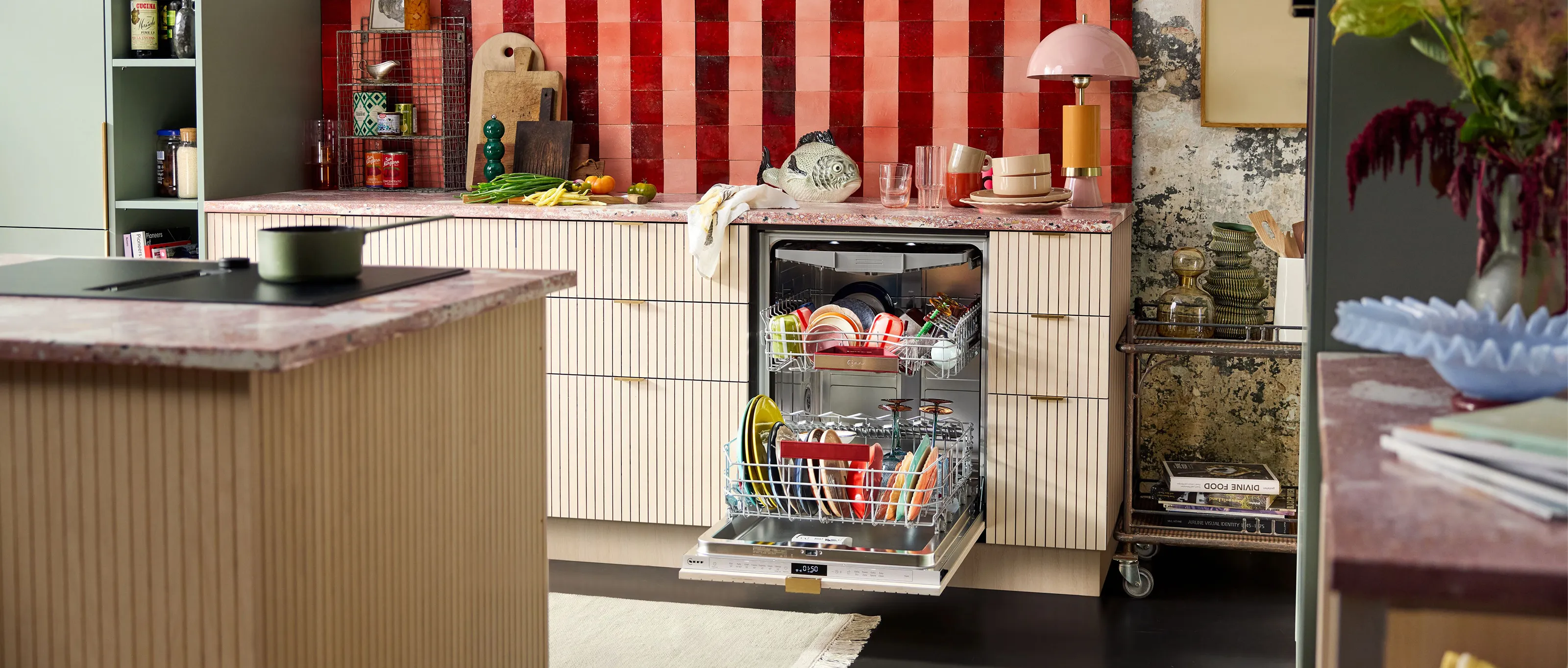 A modern kitchen featuring a dishwasher filled with colorful dishes and a mix of plants and decor elements