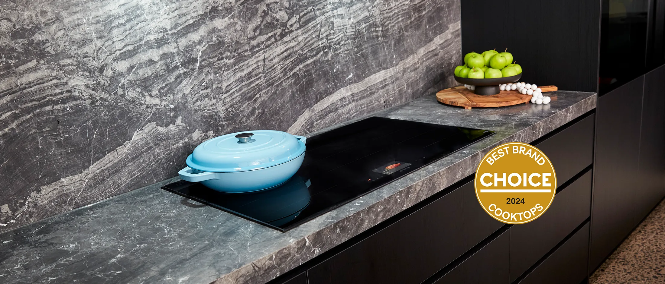 Modern kitchen with a Bosch built-in oven, minimalist wooden cabinetry, and wide induction hob on the island.