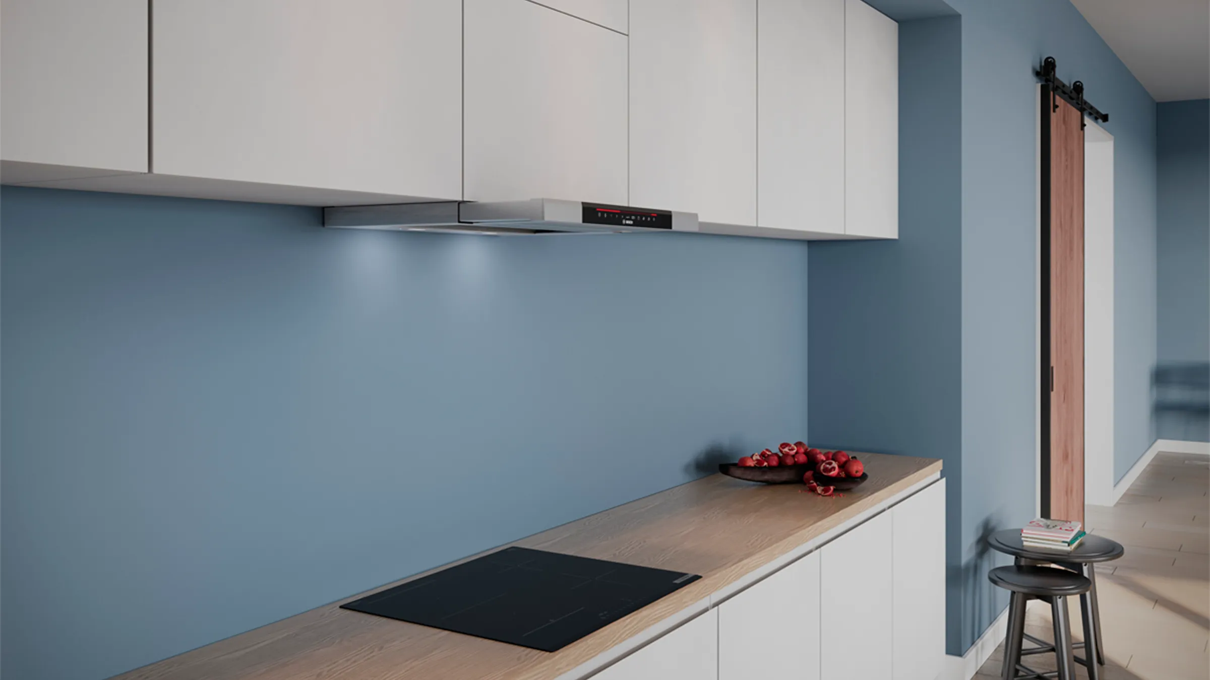 Modern kitchen with built-in stovetop, extractor hood, blue wall, and minimal decor.