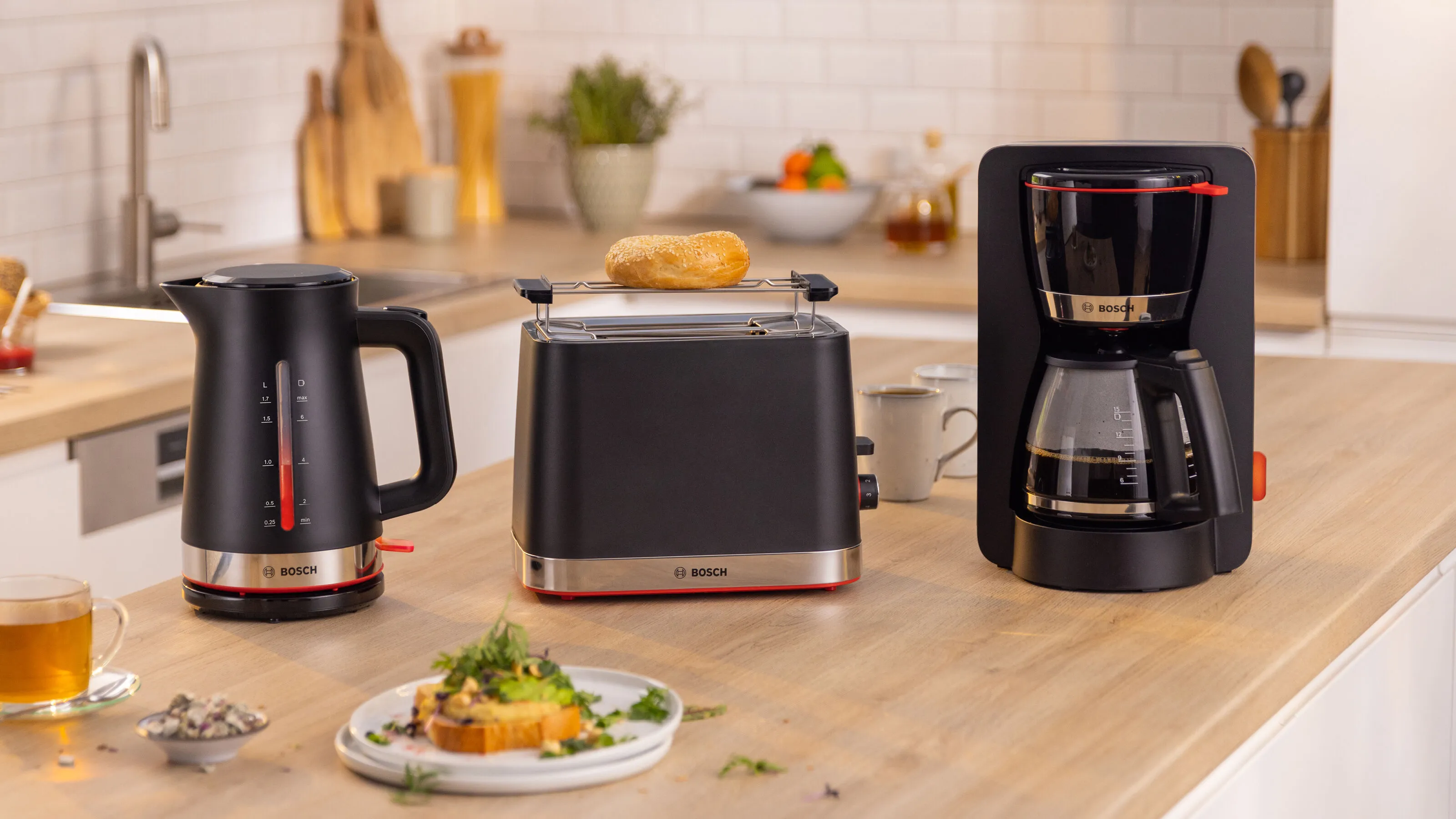 Set per la colazione Bosch con un bollitore, un tostapane e una macchina da caffè nera, su un piano di lavoro della cucina con un'etichetta "Mix & Match".