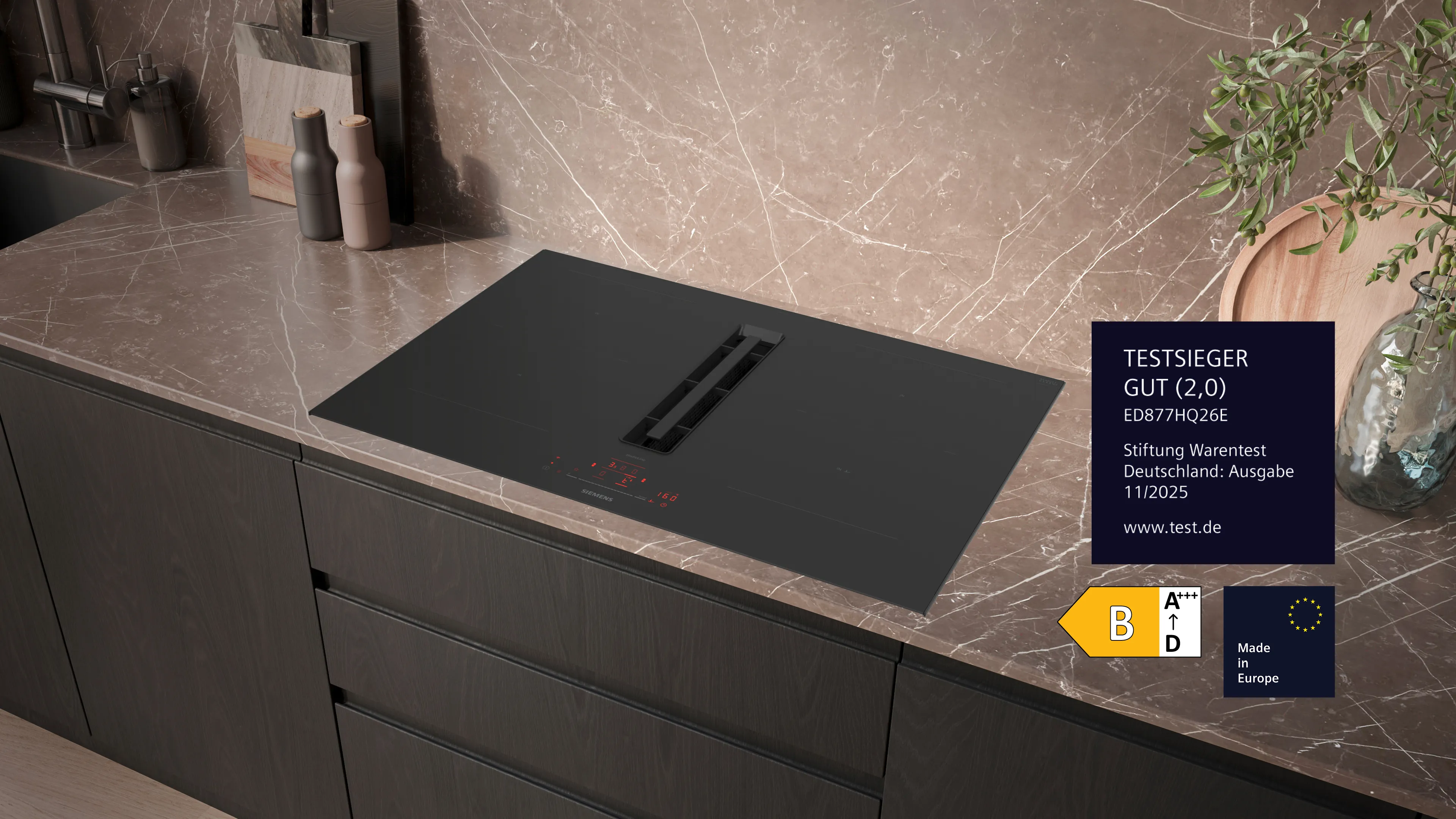 Siemens-Induktionskochfeld mit integrierter Dunstabzugshaube, dampfender Pfanne und modernem Essbereich im Hintergrund.