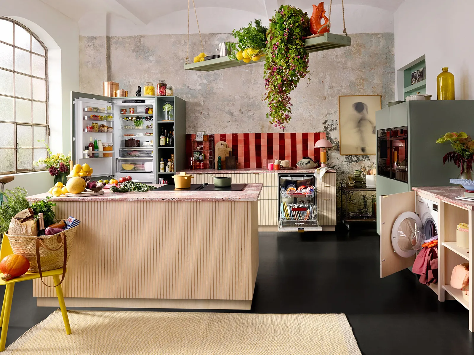 Helle Küche mit bunter Dekoration, offenem Kühlschrank, stilvoller Insel und frischem Obst und Gemüse auf der Arbeitsfläche.