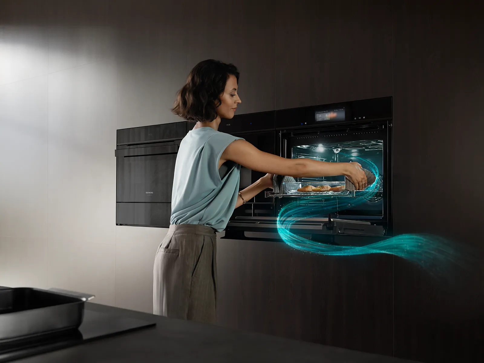 Woman in red dress baking in kitchen, oven open, cozy home interior.