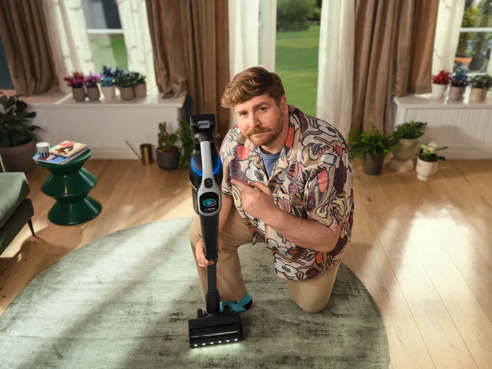 Man holding bosch unlimited vacuum in living room