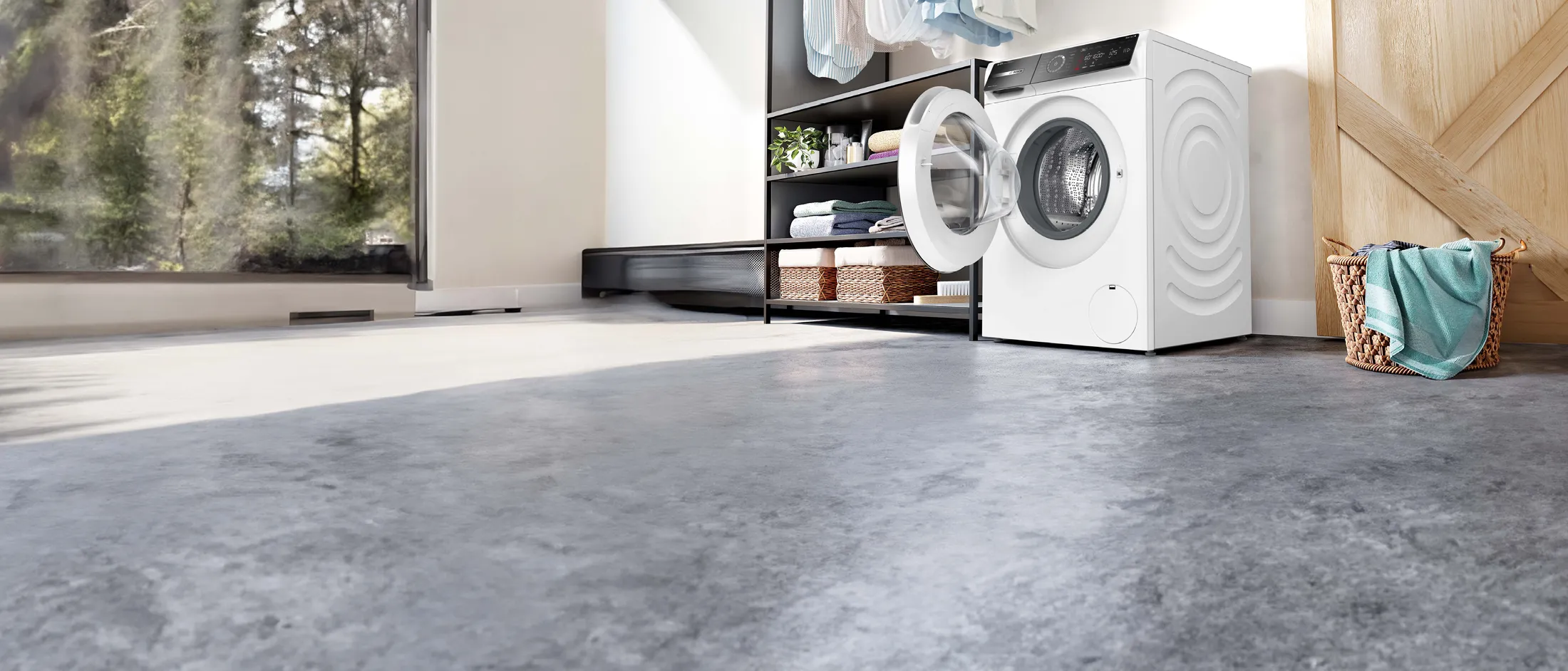 wasmachine 11kg vulgewicht met deur open in kamer met grijze vloer