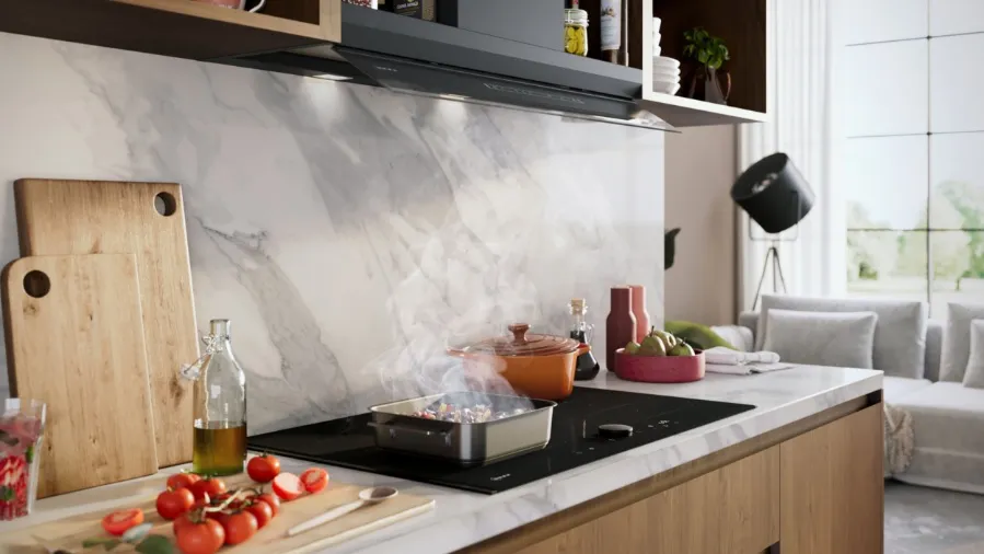 Modern keukenblad met een stoomende pan op het fornuis, verse tomaten, snijplanken, een fles olie en stijlvolle decoratie bij het woongedeelte.