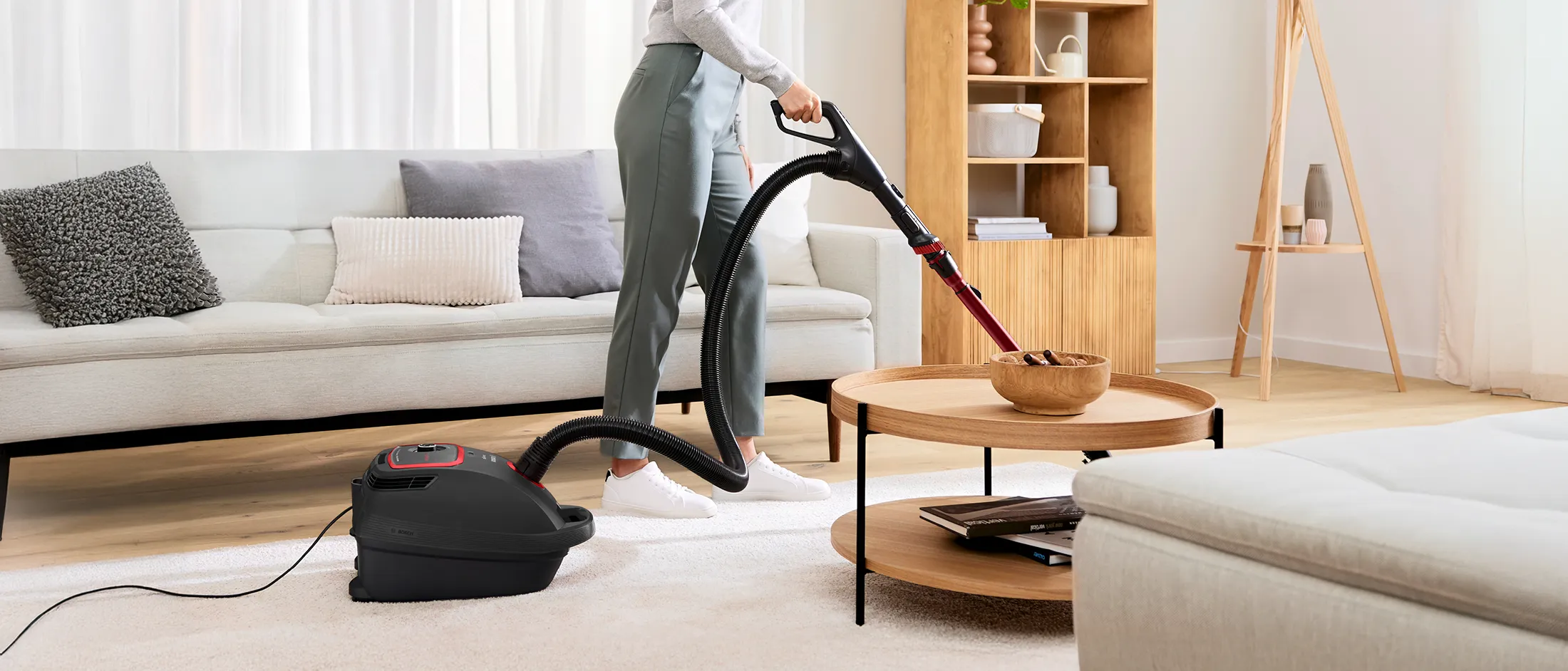 Person vacuuming floor using Bosch Bagged Series 6 model.