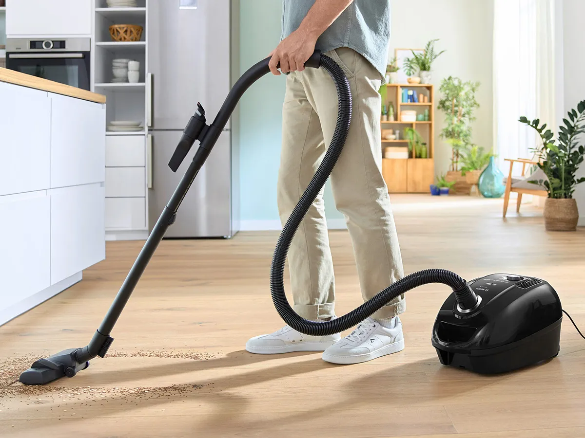 Bosch bagged series 4 model being used to clean a wooden kitchen floor.