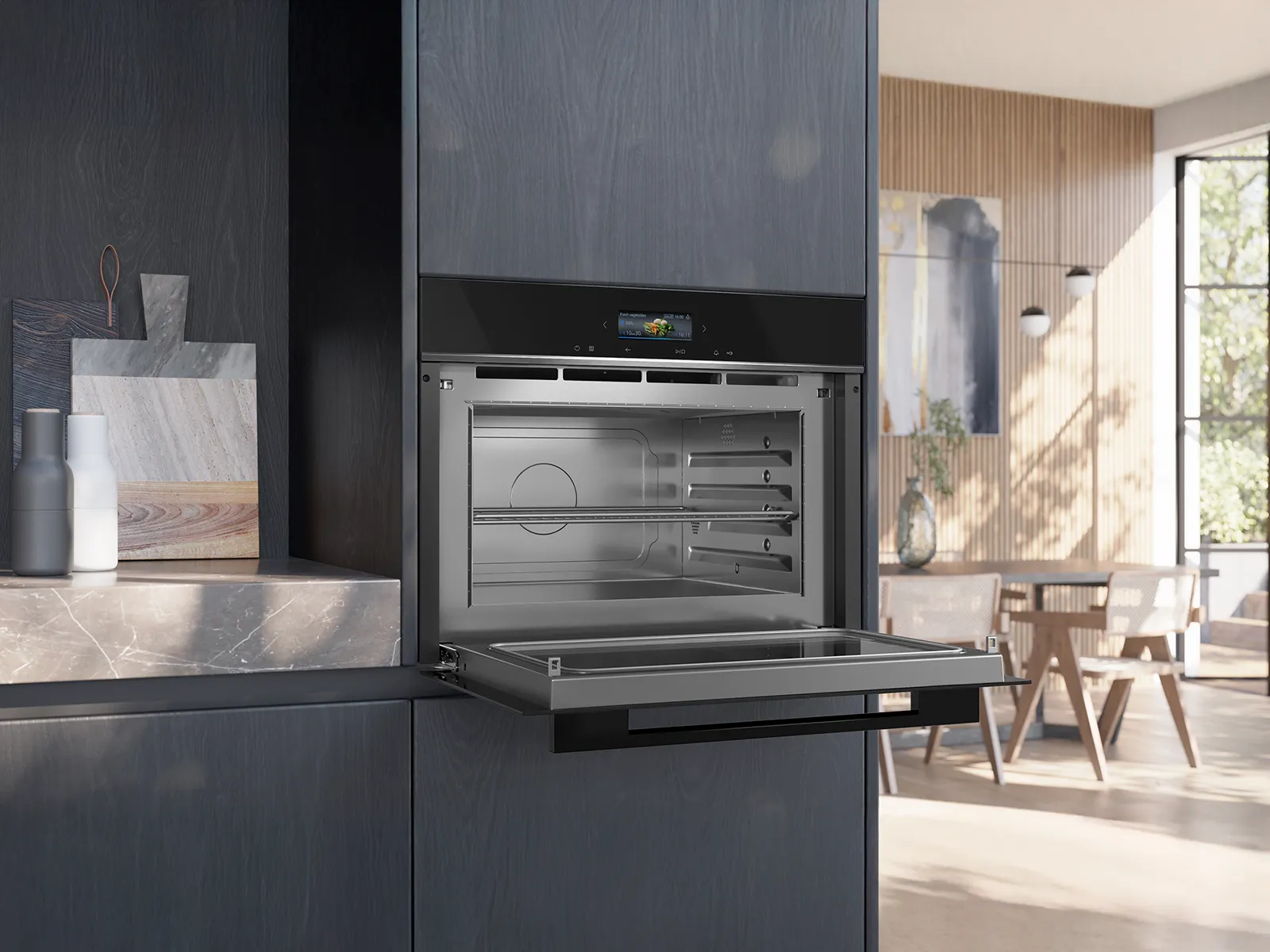 A modern kitchen features a sleek, open oven with a black finish, set within dark cabinetry, highlighting a minimalistic design.