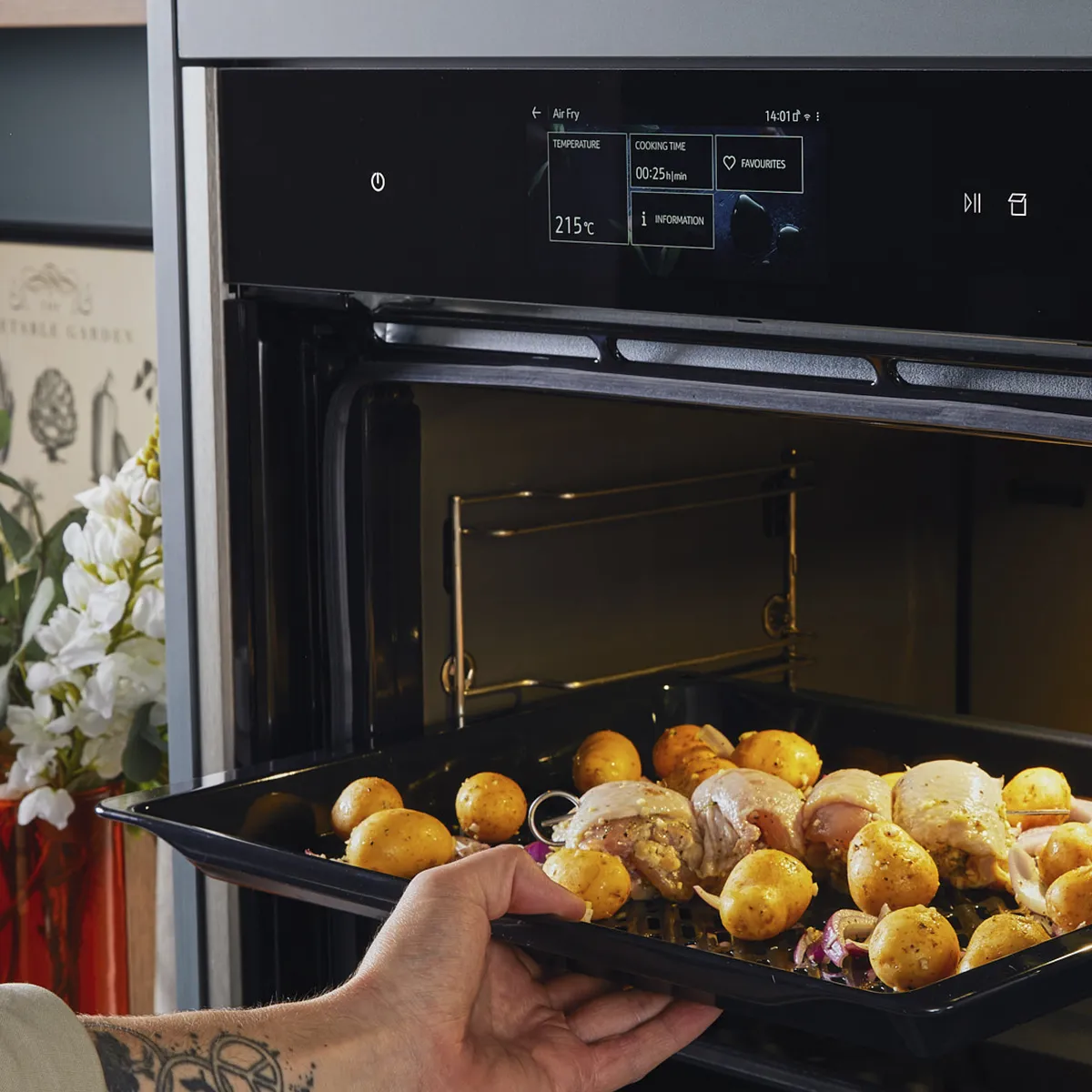 Transferring chicken breasts, potatoes and onions to an oven