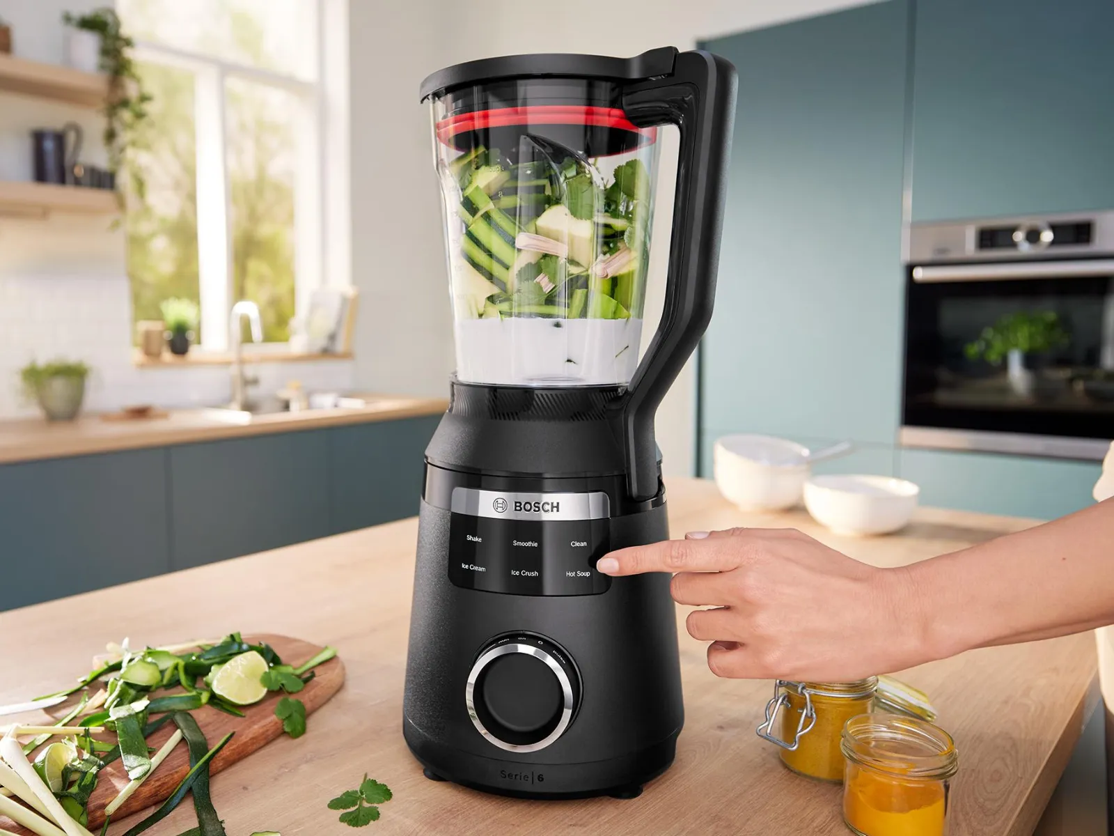 Licuadora VitaPower Serie 6 de acero inoxidable con batidos y platos en un estante de la cocina.