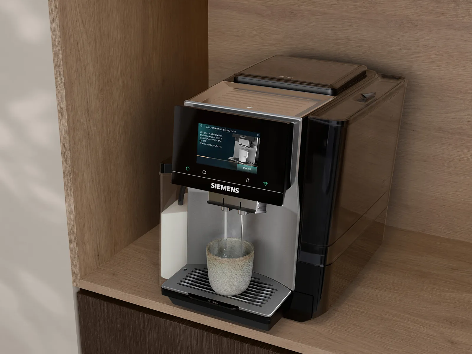 Siemens coffee machine on a wooden shelf showing “Cup warming function”; twin spouts pouring into a light ceramic cup on the drip tray; black and silver finish against a light wood background.