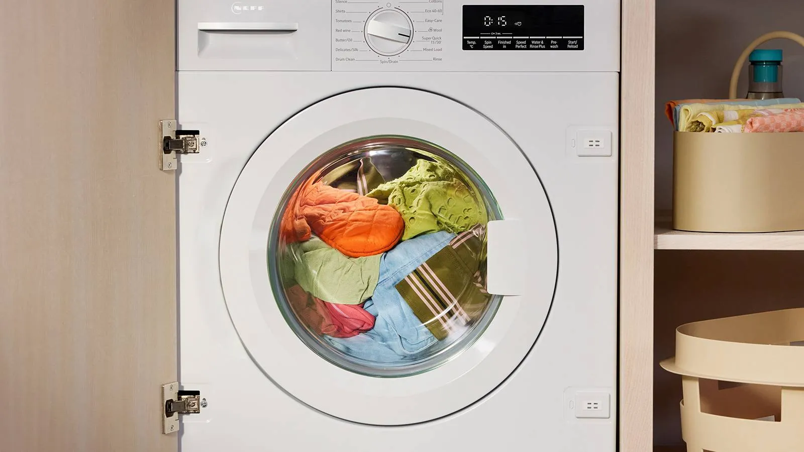 Washing machine with brightly coloured clothes inside