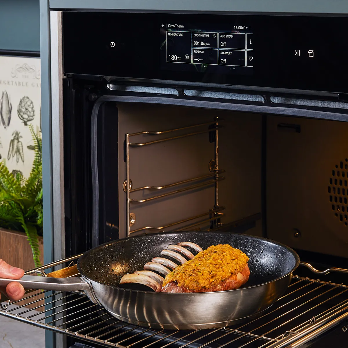 Transferring pistachio crusted rack of lamb to an oven.