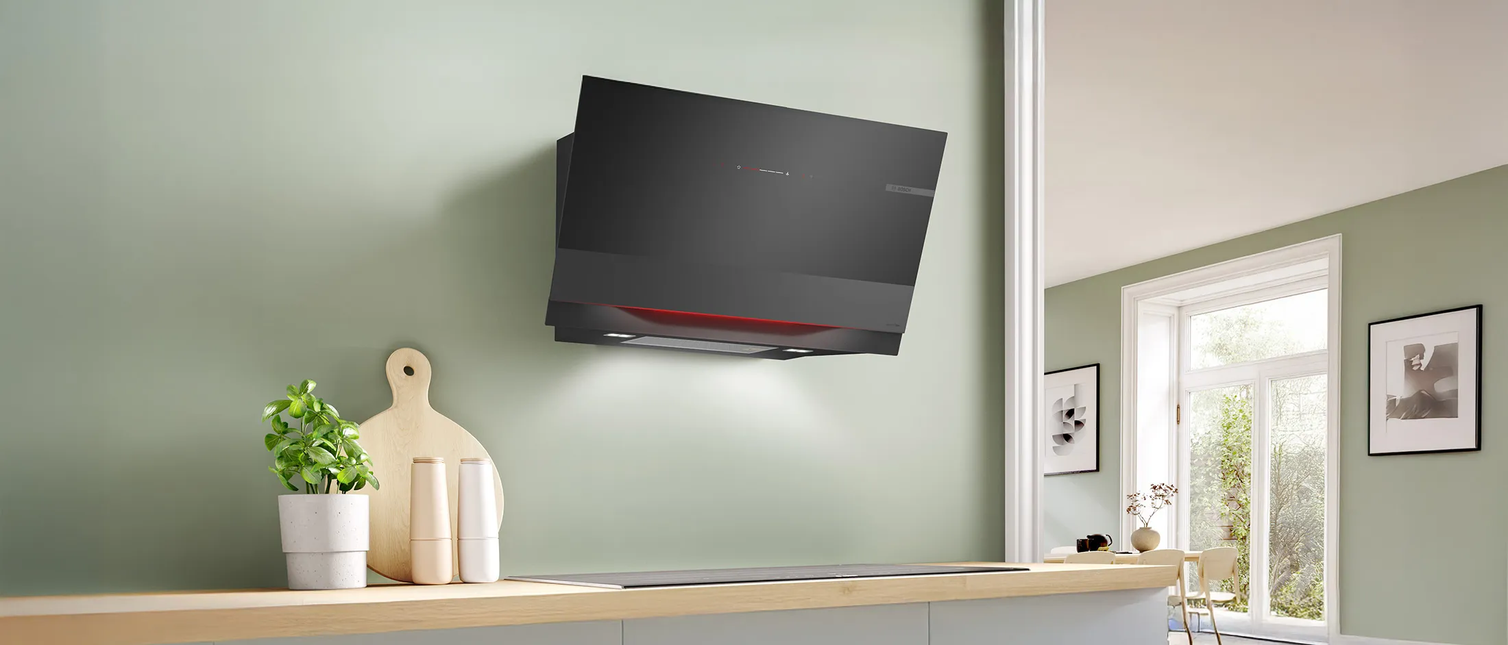 Modern kitchen with a sleek black hood, steam rising from a pan and wooden countertop.