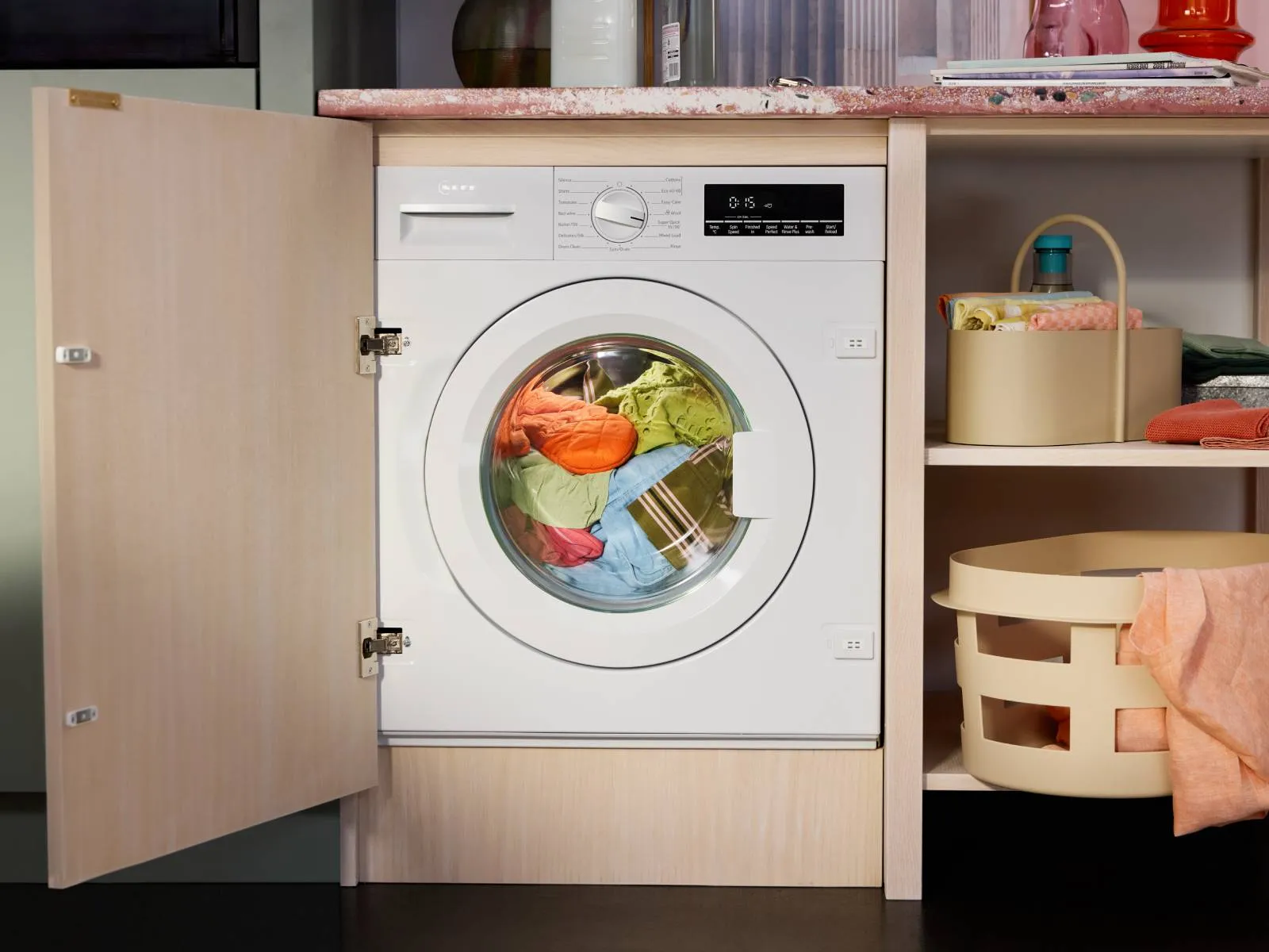 Washing machine with a basket of clothes inside, ready for a laundry cycle.