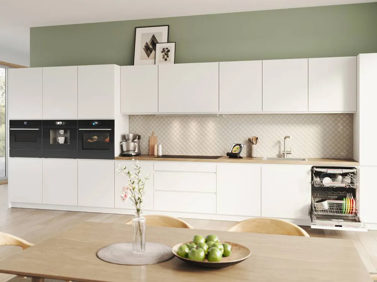 View of a Bosch kitchen with a green wall and many appliances.