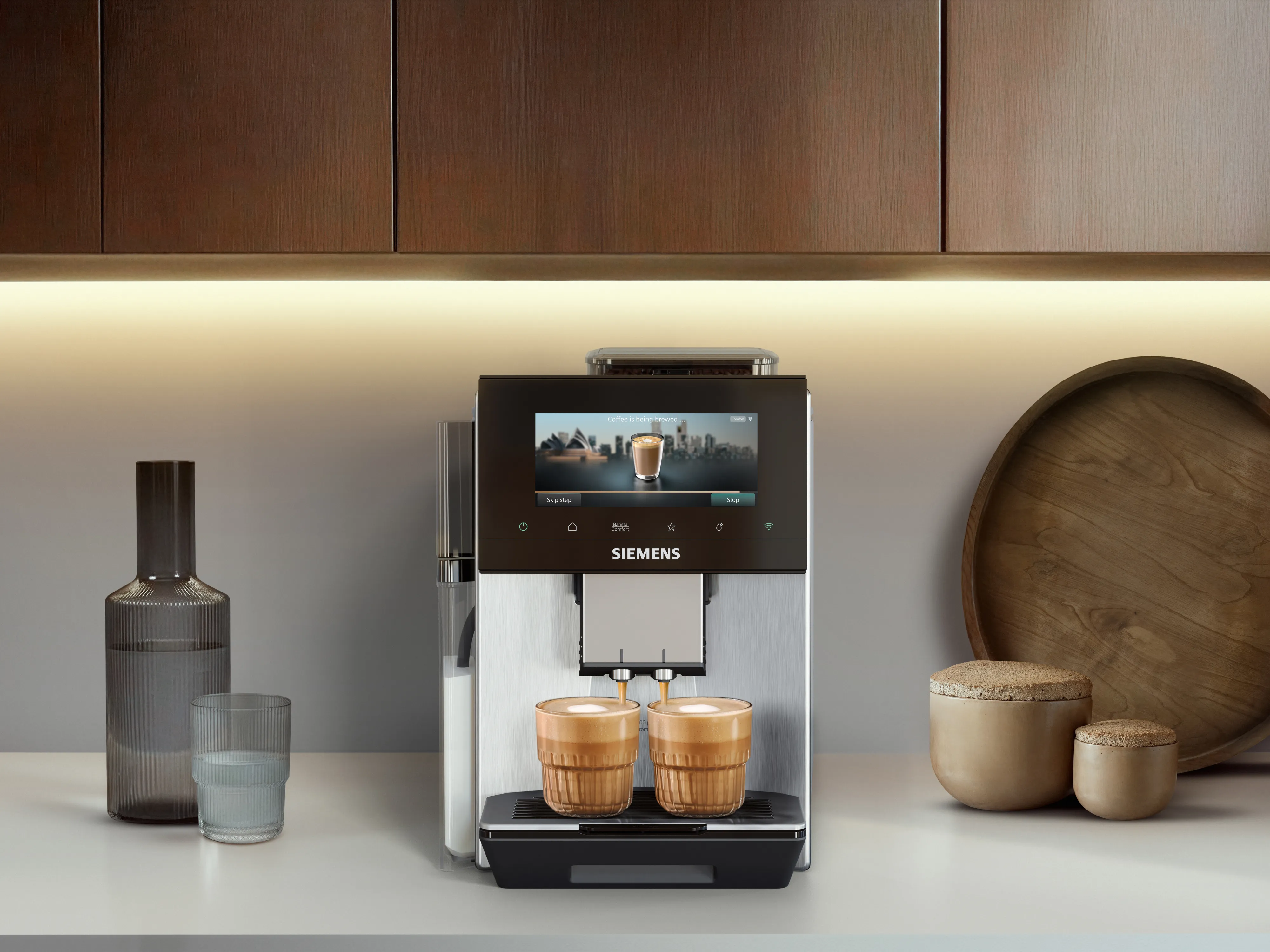 Une machine à café Siemens sur un plan de travail, accompagnée de diverses boissons à base de café présentées dans des verres à côté.