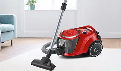 Woman climbs the stairs with a bagless cylinder model.