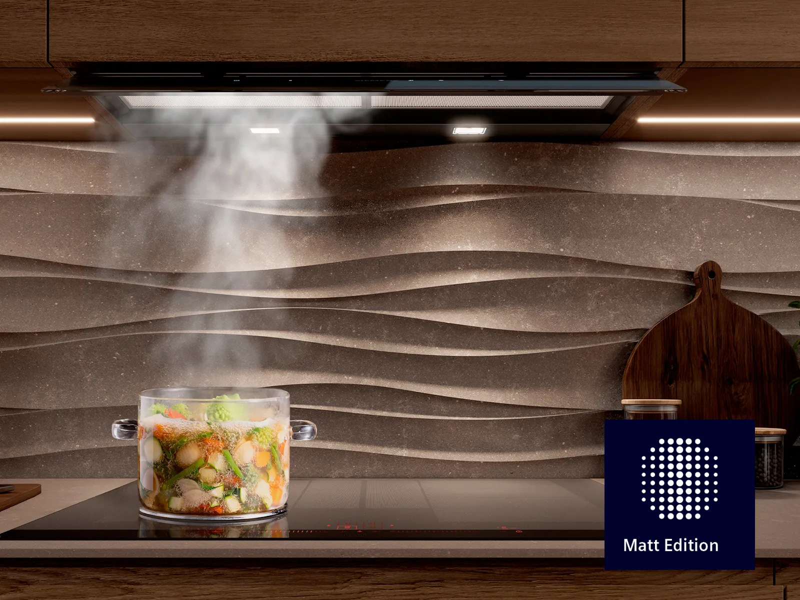 Moderne Küche mit einem Glasgericht mit dampfendem Gemüse auf einem Induktionskochfeld unter einer Dunstabzugshaube.