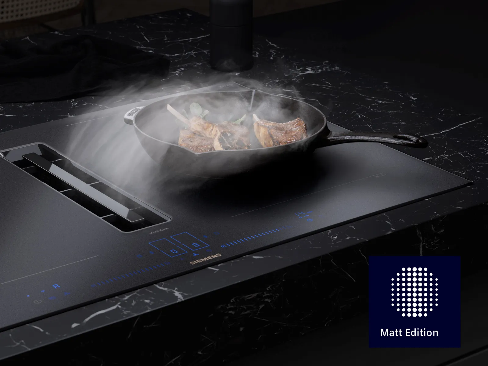 Ein Dunstabzugs-Kochfeld mit mattierter Oberfläche, aus dem Rauch einer Pfanne mit Fleisch und Gemüse aufsteigt.