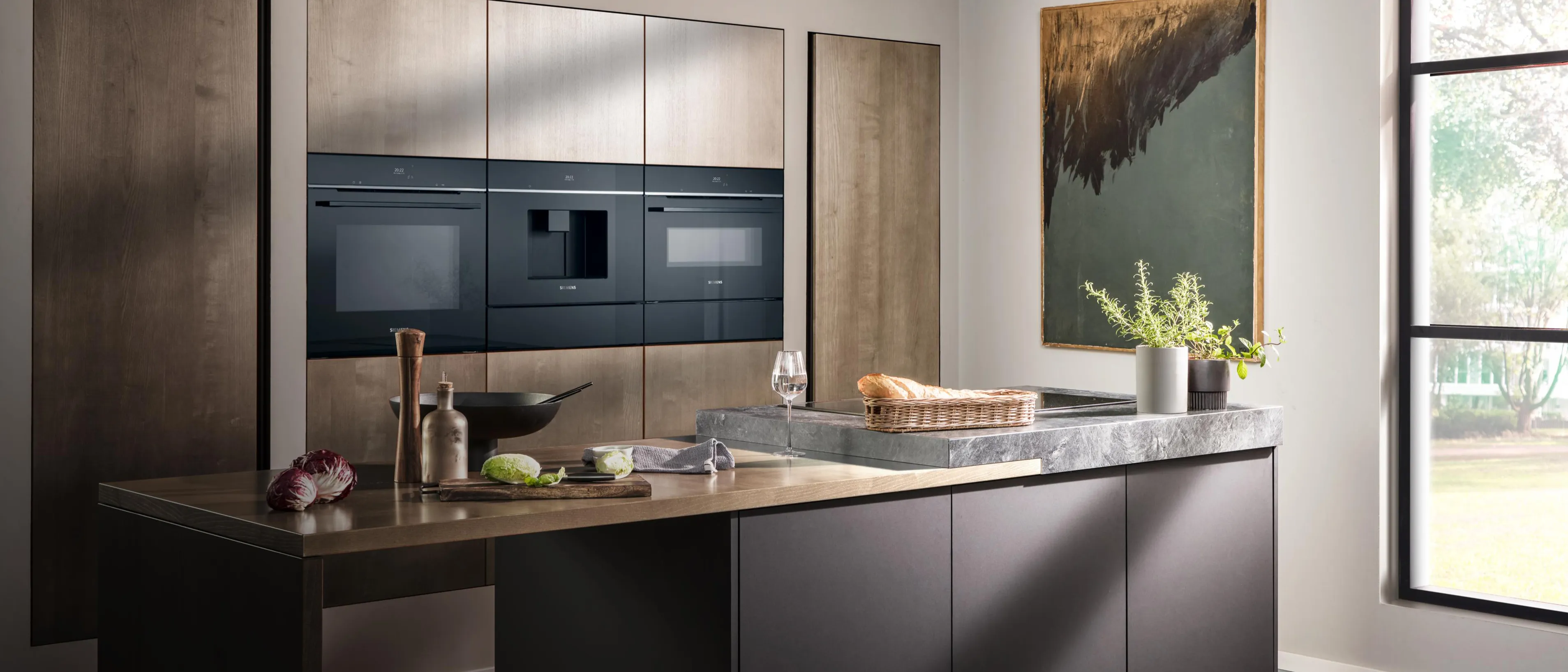 Nowoczesna kuchnia Siemens z parującym garnkiem na płycie indukcyjnej, świeżymi warzywami i składnikami do gotowania na blacie.