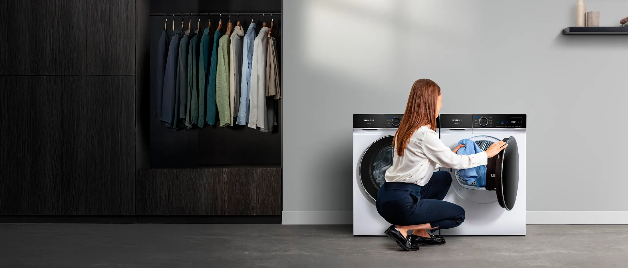 Una joven introduce una prenda en una secadora iQ700 de Siemens.