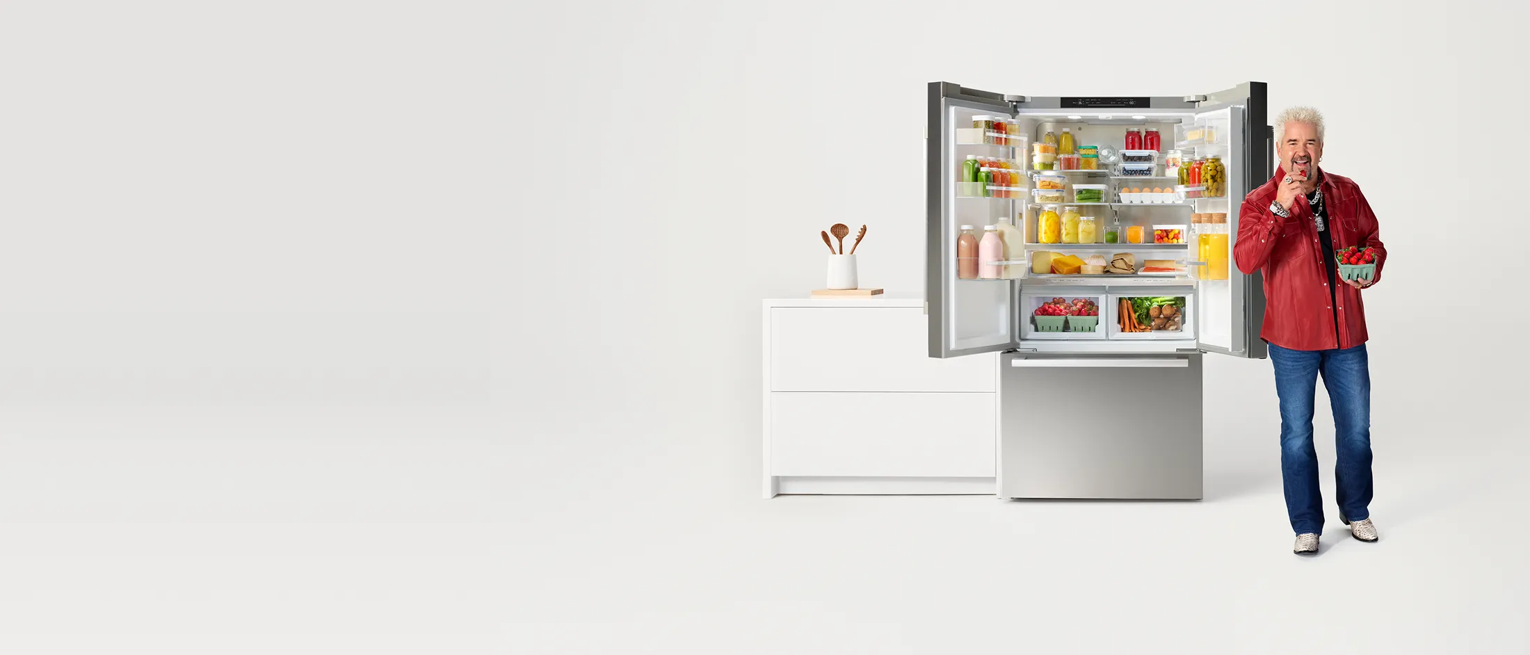Guy Fieri in front of opened Bosch french door refrigerator full of produce
