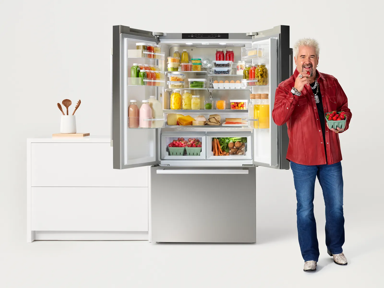 Guy Fieri in front of opened Bosch French Door Refrigerator filled with produce