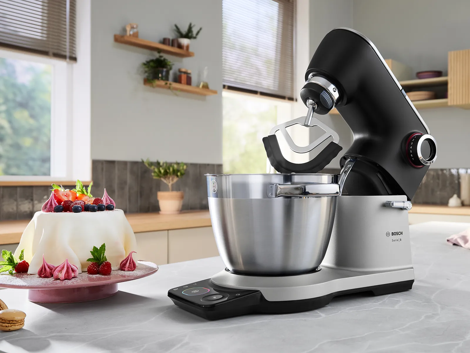 Crveni Bosch kuhinjski robot na kuhinjskom stolu.