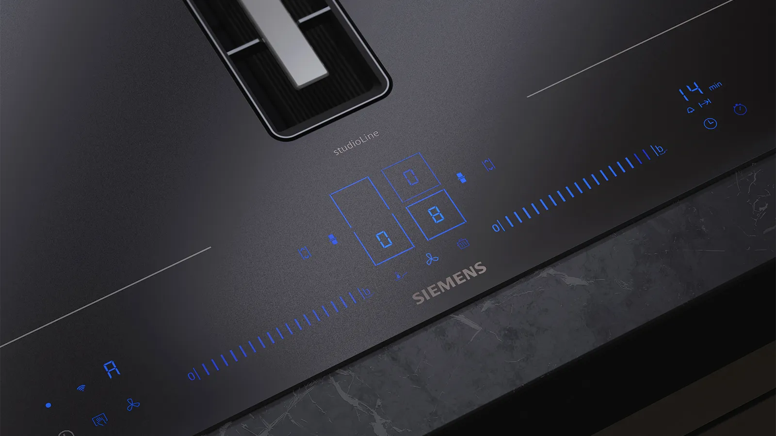 Sizzling meat on a black induction cooktop, paired with fresh lemons and a stylish marble countertop