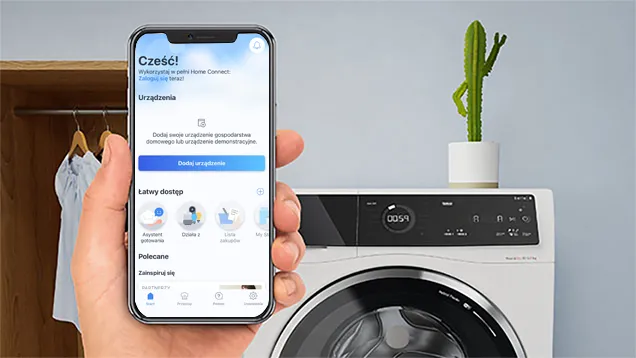 Osoba trzymająca smartfon. Nowoczesna kuchnia w tle. 