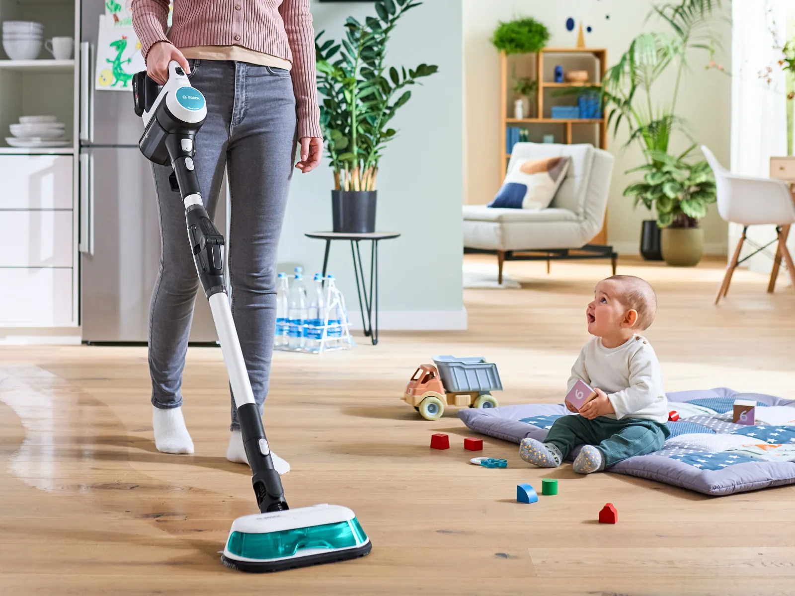 Woman vacuuming living room with new 2-in-1 vacuum and mop, surrounded by plants and home decor.
