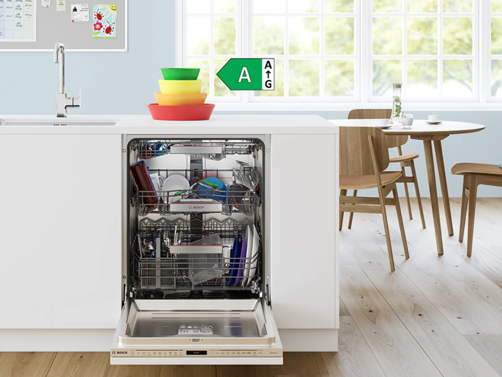 מטבח מודרני עם כלים פתוחים, קערות צבעוניות ושולחן אוכל באור טבעי.