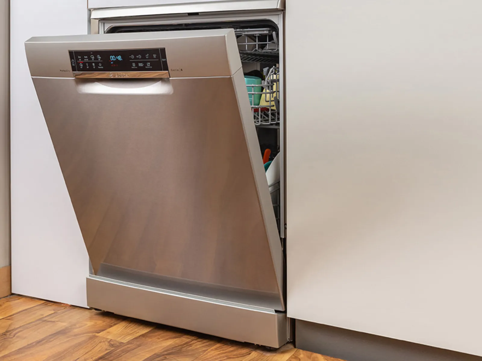 מדיח כלים מנירוסטה עם דלת פתוחה, חושפים מדפים ובקרות פנימיות.