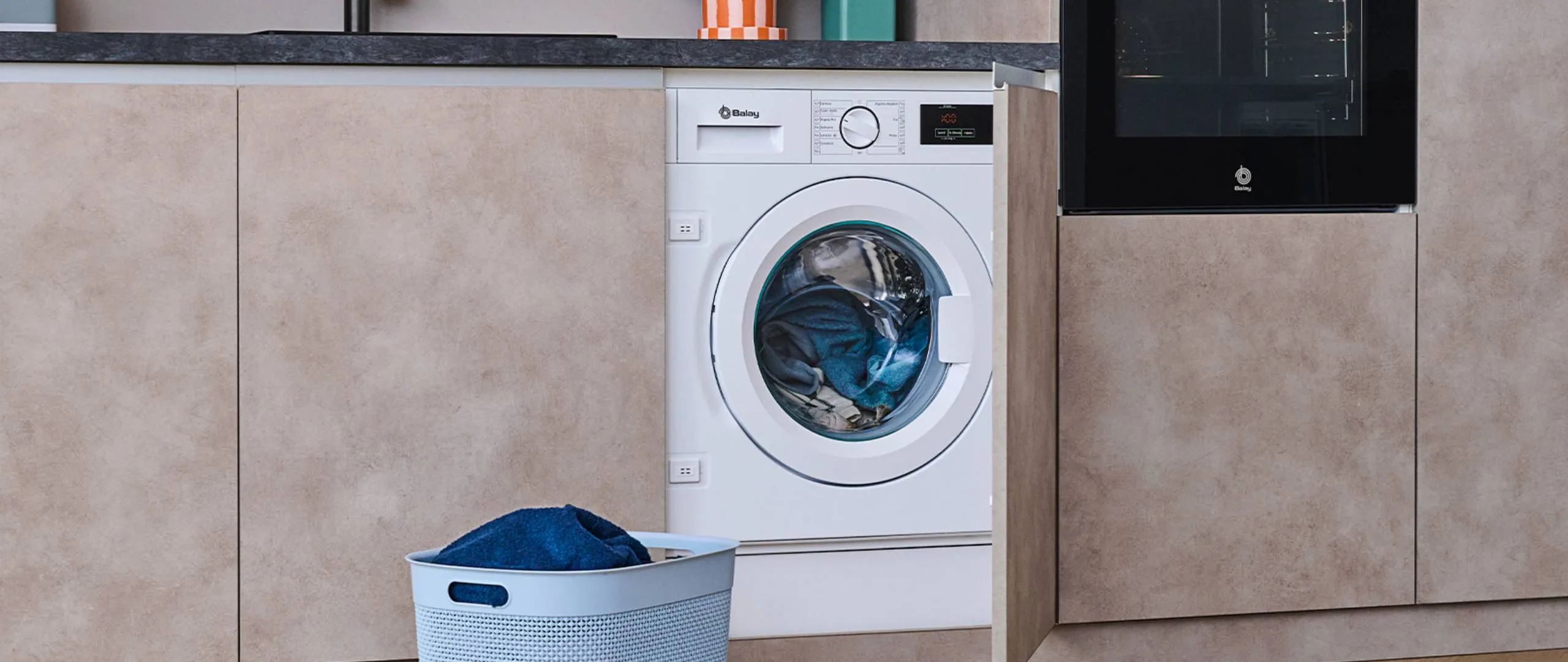 Lavadora integrable Balay instalada en una cocina marrón.