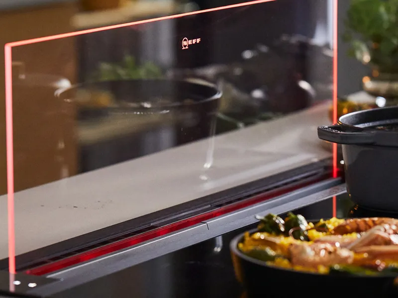 Ο βυθιζόμενος απορροφητήρας σε λειτουργία με δύο σκεύη μαγειρικής μπροστά του.