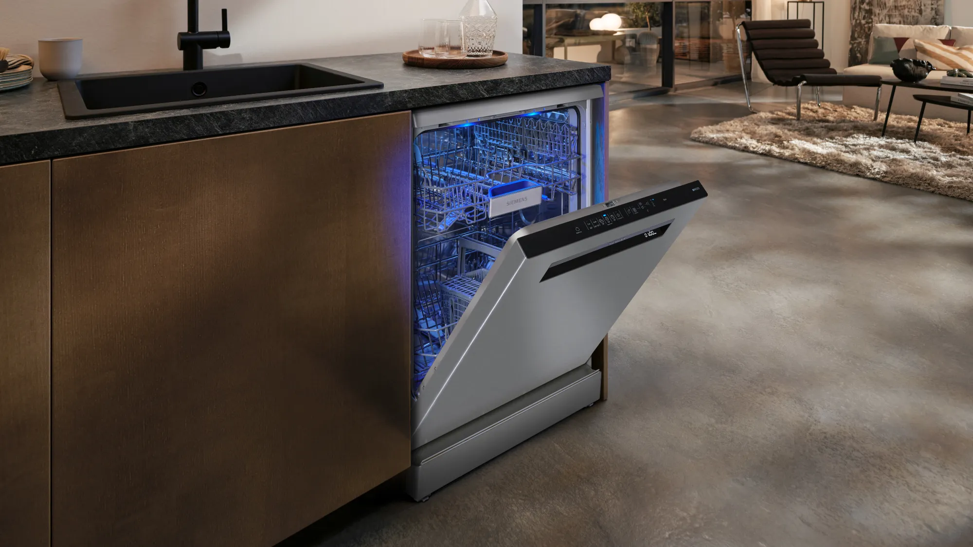 An open dishwasher with a blue interior light in a modern kitchen.