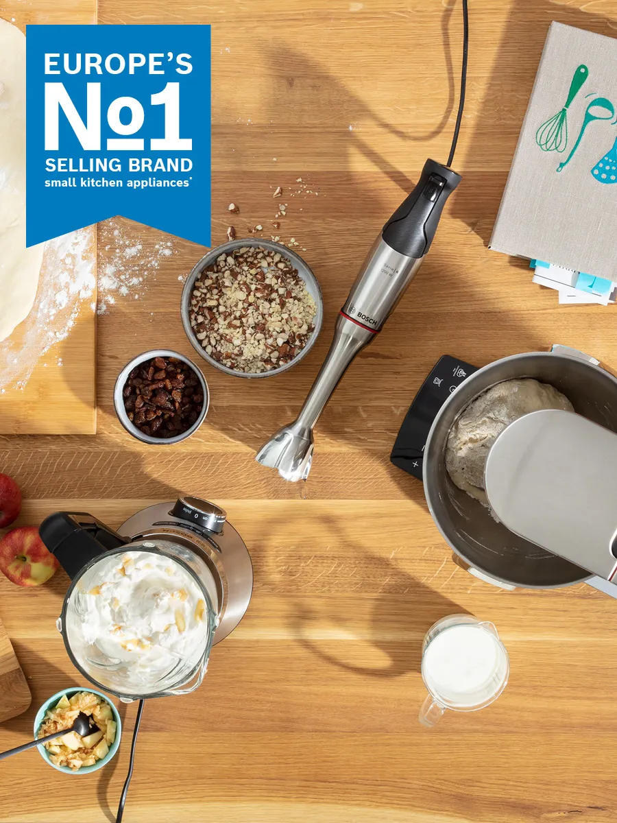 Overhead view of different food dishes sat on table, with Europe's Number 1 Brand Food Preparation Appliances icon
