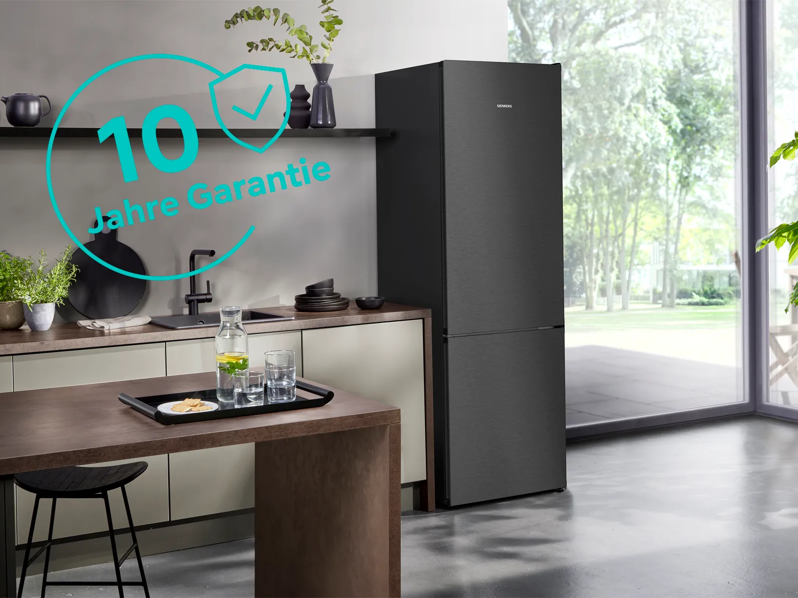 Eine freistehende Siemens Kühl-Gefrier-Kombination in einer hellen Küche. Auf dem Bild ist ein Störer mit der Information über die 10-Jahre Herstellergarantie.